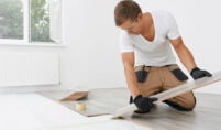 Master,Lays,The,Laminate.,Man,Installing,New,Laminated,Wooden,Floor